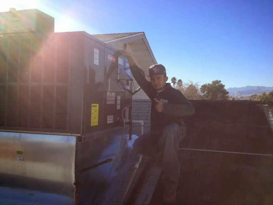 HVAC technician performing AC Tune-Up on a rooftop unit in West Deptford